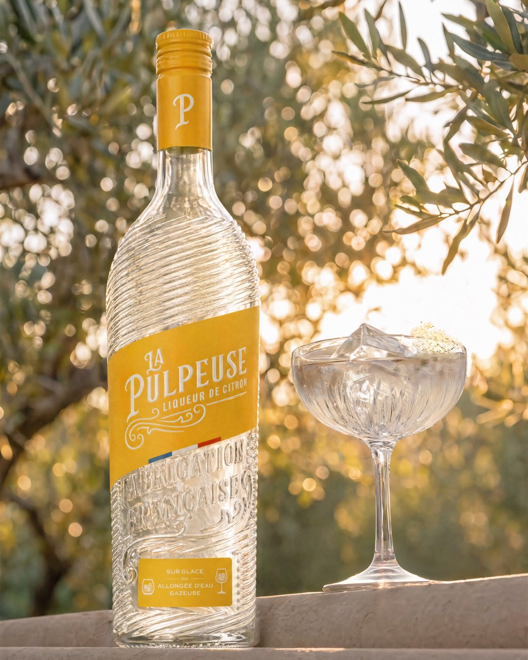 Bouteille La Pulpeuse et cocktail dans les oliviers
